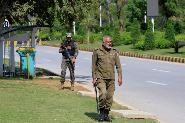 لقطة لضابط شرطة وجندي من القوات العسكرية يحرسان طريقا مهجورا يؤدي إلى فندق "سيرينا". - سبوتنيك عربي