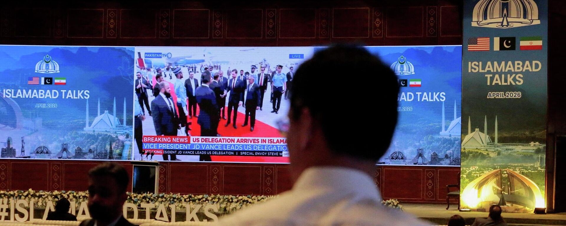 شاشة داخل المركز الإعلامي تعرض وصول نائب الرئيس الأمريكي، جي دي فانس، ووفود أخرى من الولايات المتحدة، في اليوم المتوقع أن تعقد فيه الولايات المتحدة وإيران محادثات سلام، في إسلام آباد، باكستان، 11 نيسان/ أبريل 2026 - سبوتنيك عربي, 1920, 11.04.2026