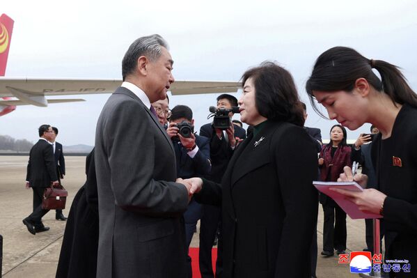 وزير الخارجية الصيني وانغ يي، ووزيرة خارجية كوريا الديمقراطية الشعبية، تشون سون هي، يتصافحان في مطار بيونغ يانغ الدولي في بيونغ يانغ في كوريا الديمقراطية الشعبية، خلال أول زيارة قام بها وانغ يي إلى كوريا الديقراطية الشعبية منذ عام 2019. - سبوتنيك عربي