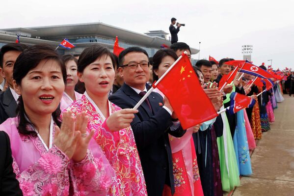 يستقبل الناس وزير الخارجية الصيني وانغ يي، في مطار بيونغ يانغ الدولي في بيونغ يانغ، في كوريا الديمقراطية الشعبية، خلال أول زيارة قام بها وانغ يي إلى كوريا الديقراطية الشعبية منذ عام 2019. - سبوتنيك عربي