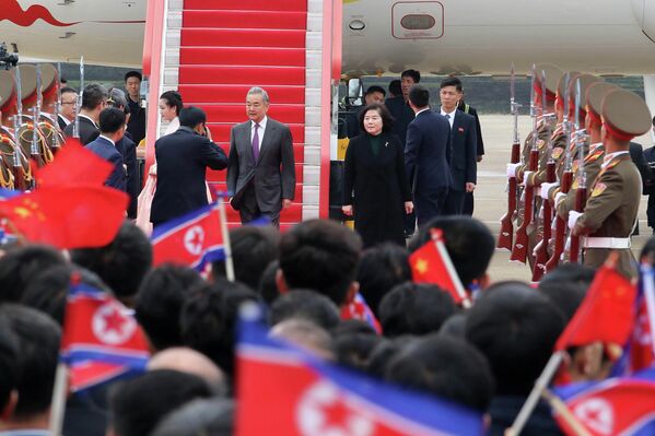 وصول وزير الخارجية الصيني وانغ يي (في الوسط)، إلى مطار "بيونغ يانغ" الدولي في كوريا الديمقراطية الشعبية، خلال أول زيارة قام بها وانغ يي إلى كوريا الديقراطية الشعبية منذ عام 2019. - سبوتنيك عربي