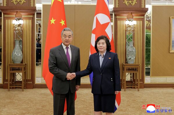 وزير الخارجية الصيني وانغ يي، ووزيرة خارجية كوريا الديمقراطية الشعبية، تشون سون هي، يتصافحان خلال لقائهما في بيونغ يانغ، خلال أول زيارة قام بها وانغ يي إلى كوريا الديقراطية الشعبية منذ عام 2019. - سبوتنيك عربي