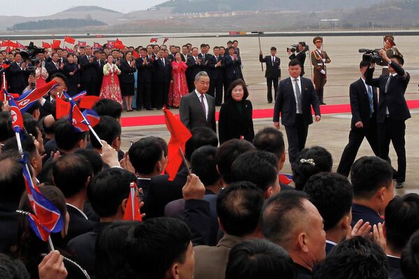 وزير الخارجية الصيني وانغ يي (في الوسط إلى اليسار) يسير مع وزيرة خارجية كوريا الديمقراطية الشعبية تشون سون هوي (في الوسط إلى اليمين) لدى وصوله إلى مطار بيونغ يانغ الدولي. - سبوتنيك عربي