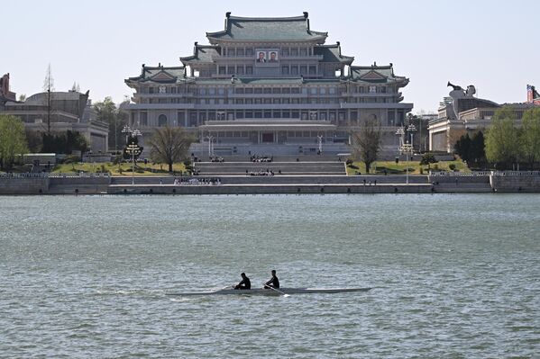 صورة تظهر مكتبة بيونغ يانغ المركزية (قصر الشعب للدراسة) على ضفاف نهر تايدونغ الذي يظهروسطه قاربا صغيرا يحمل على متنه رجلين. - سبوتنيك عربي