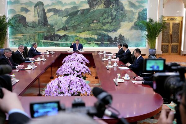 صورة عامة تظهر الرئيس الصيني، ووزير الخارجية الروسي، ومسؤولين من البلدين يجلسون إلى طاولة الاجتماع، الذي عقد في قاعة "الشعب الكبرى" - سبوتنيك عربي