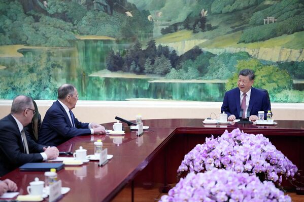 الرئيس الصيني يتحدث إلى لافروف، خلال الاجتماع الذي جمعهما بحضور مسؤولين بارزين من البلدين، في قاعة "الشعب الكبرى" - سبوتنيك عربي