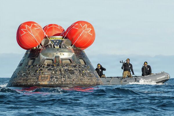 غواصون من البحرية الأمريكية، يُجرون مسحًا للكشف عن المواد الخطرة في وحدة طاقم "أرتميس 2"، بعد هبوطها في المحيط الهادئ قبالة سواحل كاليفورنيا - سبوتنيك عربي