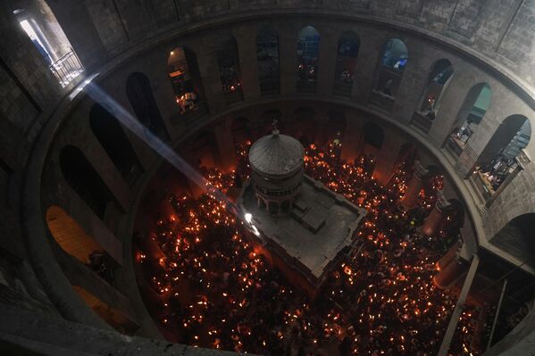 لقطة علوية تظهر مصلين يحملون الشموع خلال مراسم إشعال النار المقدسة، في كنيسة القيامة،في القدس. - سبوتنيك عربي