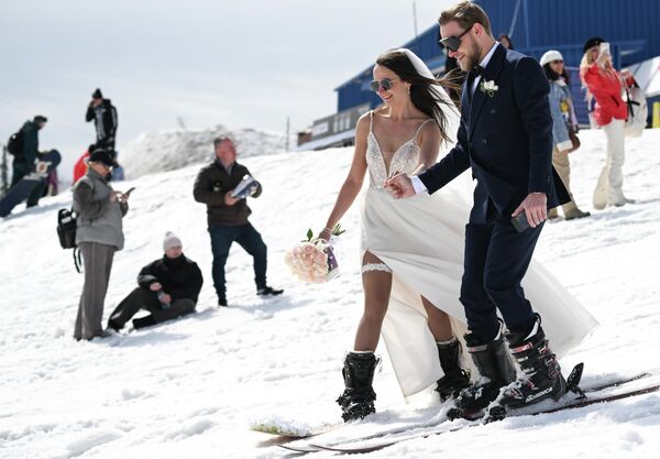 عروسان يشاركان في سباق التزلج "الزفاف" على منحدر جبل زيلينيا خلال مهرجان "جريلكا فست". - سبوتنيك عربي