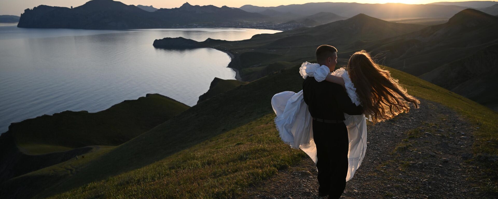 عروسان حديثا الزواج على جبل دجان-كوتاران في منتزه المناظر الطبيعية والترفيهي بين قريتي أوردجونيكيدزه وكوكتيبيل في شبه جزيرة القرم. - سبوتنيك عربي, 1920, 20.04.2026