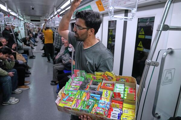 بائع متجول يبيع العلكة داخل قطار الأنفاق في طهران. - سبوتنيك عربي