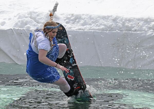 مشاركة في مهرجان "غورنولوزنيك" السنوي بمنتزه بوبروفي لوغ في كراسنويارسك، حيث يتزلج المشاركون بملابس كرنفالية عبر مسبح بطول 25 مترا عند قاعدة منحدر التزلج. - سبوتنيك عربي