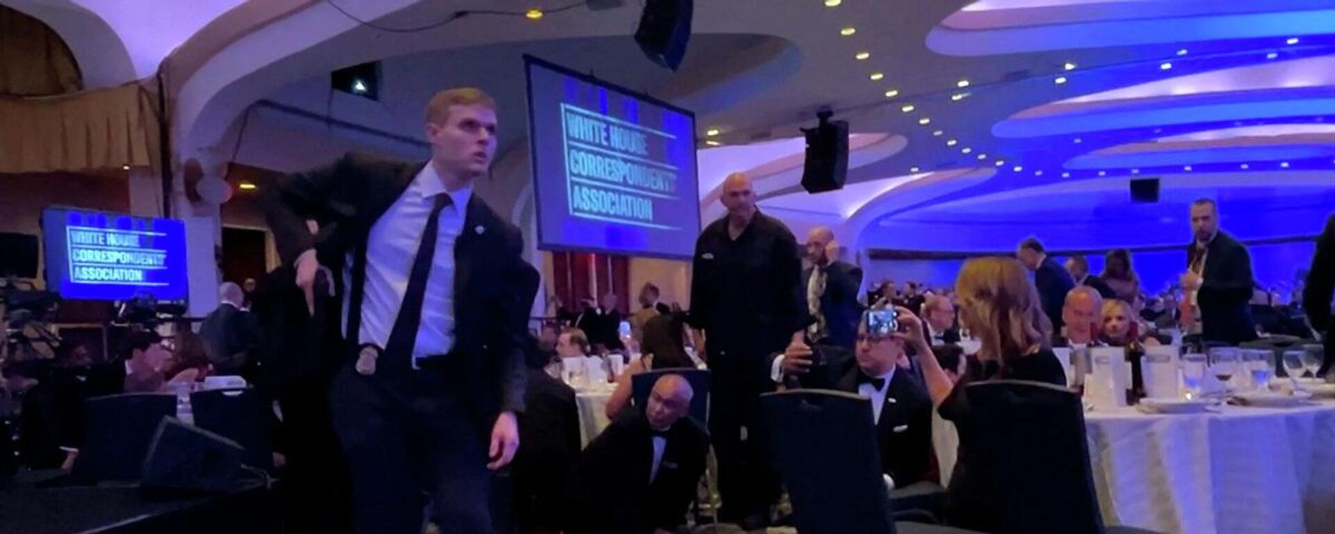 عنصر من الخدمة السرية يستل مسدسه بعد إجلاء الرئيس الأمريكي، دونالد ترامب، إثر إطلاق نار بحفل مراسلي البيت الأبيض بواشنطن، 25 نيسان/ أبريل 2026 - سبوتنيك عربي, 1920, 26.04.2026