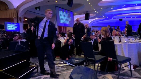 عنصر من الخدمة السرية يستل مسدسه بعد إجلاء الرئيس الأمريكي، دونالد ترامب، إثر إطلاق نار بحفل مراسلي البيت الأبيض بواشنطن، 25 نيسان/ أبريل 2026 - سبوتنيك عربي