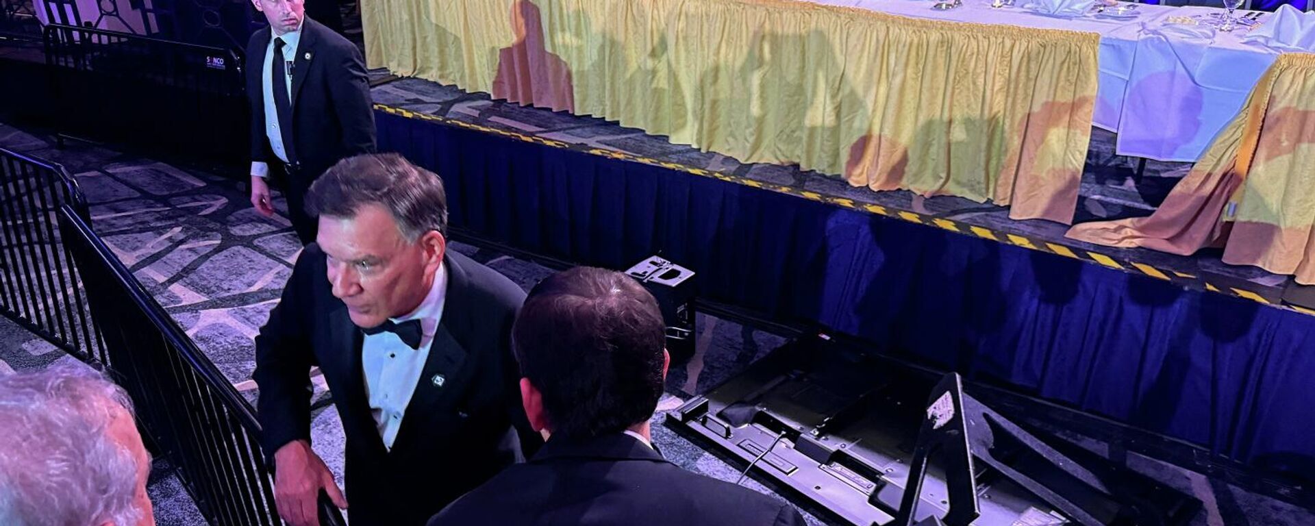 المدير التنفيذي لرابطة مراسلي البيت الأبيض، ستيف ثوما، يقف قرب شاشة مقلوبة بعد إخلاء الطاولة الرئيسية وإخراج الرئيس الأمريكي، دونالد ترامب، إثر محاولة مسلح اختراق الأمن بحفل مراسلي البيت الأبيض، واشنطن، 25 نيسان/ أبريل 2026 - سبوتنيك عربي, 1920, 26.04.2026