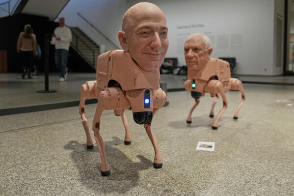 روبوتان على هيئة جيف بيزوس (إلى اليسار) وبابلو بيكاسو (إلى اليمين)، معروضان ضمن العمل الفني التركيبي المعنون "حيوانات عادية" (Regular Animals) للفنان "بيبل" (مايك وينكلمان)، وذلك في متحف "نويه ناشيونال غاليري" في برلين. - سبوتنيك عربي