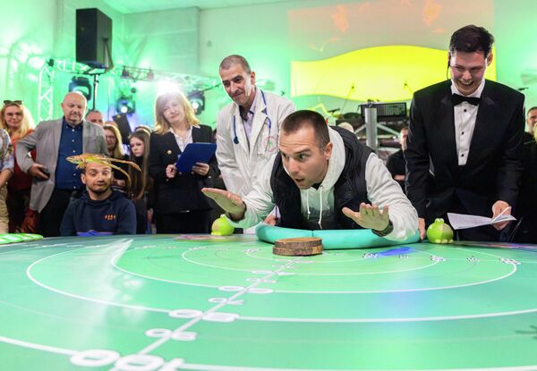 متسابق يوجه ضفدعه للقفز خلال مسابقة "ليلة الضفادع" (Frognight) للقفز في دورتها السابعة والأربعين، في لوكفي بكرواتيا، 25 أبريل 2026. - سبوتنيك عربي