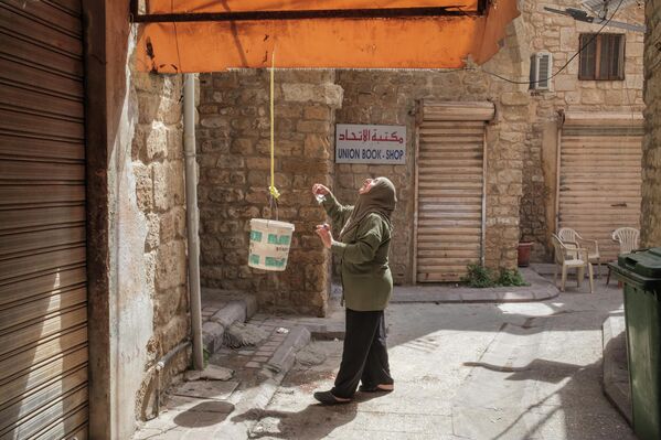 امرأة تسير في سوق قديم، في ظل وقف إطلاق نار مؤقت بين لبنان وإسرائيل، في مدينة صور جنوبي لبنان - سبوتنيك عربي