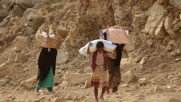 يمنيون يحملون إمدادات إغاثة - سبوتنيك عربي