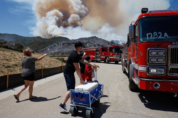 زوجان أمريكيان  يقدمان وجبات خفيفة ومشروبات لرجال الإطفاء برفقة أطفالهما خلال حرائق الغابات في كاليفورنيا.  - سبوتنيك عربي