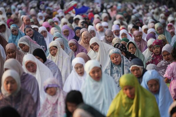 نساء يؤدين صلاة الفجر بمناسبة عيد الأضحى المبارك في أحد شوارع جاكرتا، إندونيسيا. - سبوتنيك عربي