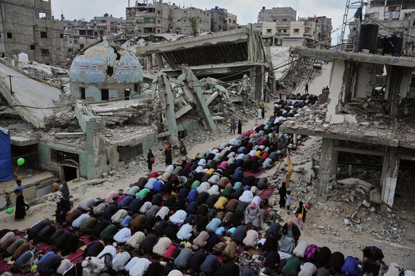 فلسطينيون يؤدون صلاة عيد الأضحى بجوار أنقاض مسجد دمره القصف الإسرائيلي في خان يونس، جنوبي قطاع غزة. - سبوتنيك عربي