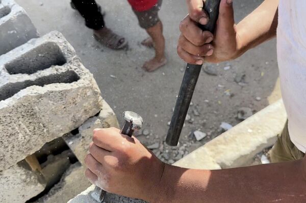 طفل فلسطيني يحمل المطرقة بدل القلم ويعمل في البناء لتأمين طعام عائلته مايو 2026  - سبوتنيك عربي