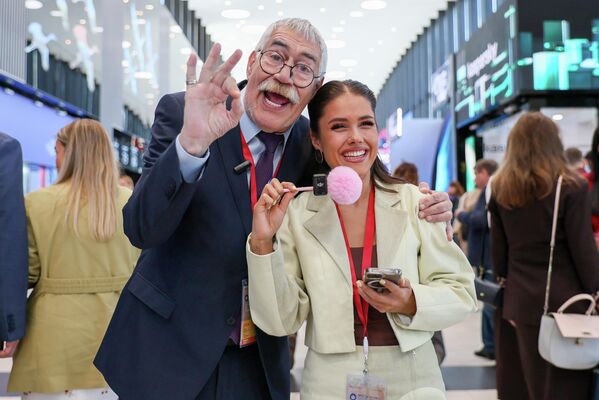 رجل وإمرأة يلتقطان صورة تذكارية ويبدو على تعابيرهما السعادة وقضاء وقت  ممتع في منتدى سان بطرسبورغ. - سبوتنيك عربي
