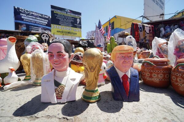 مجسّمات لرئيسة المكسيك كلوديا شينباوم، والرئيس الأمريكي دونالد ترامب، وبينهما كأس العالم لكرة القدم بالقرب من منفذ سان يسيدرو الحدودي بين المكسيك والولايات المتحدة. - سبوتنيك عربي
