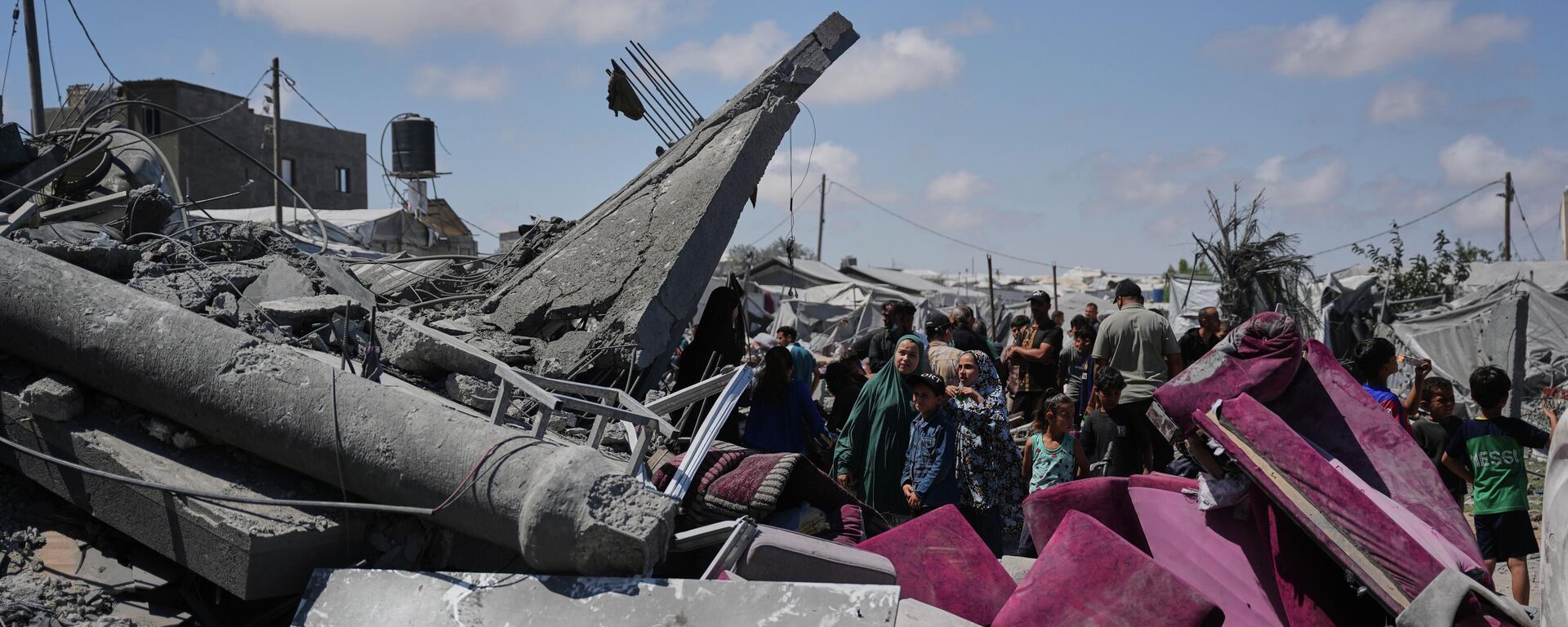 فلسطينيون يتفقدون أنقاض مبنى دُمّر جراء غارة جوية إسرائيلية في خان يونس، جنوبي قطاع غزة. - سبوتنيك عربي, 1920, 14.06.2026