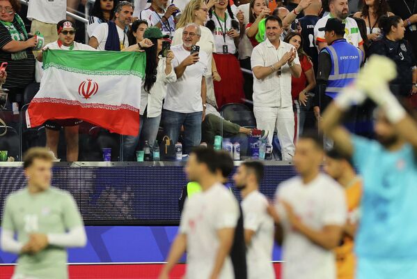تظهر الصورة أحد مشجعي منتخب إيران وهو يرفع العلم الإيراني داخل مدرجات الملعب بعد نهاية مباراة إيران ونيوزيلندا في كأس العالم 2026.  - سبوتنيك عربي