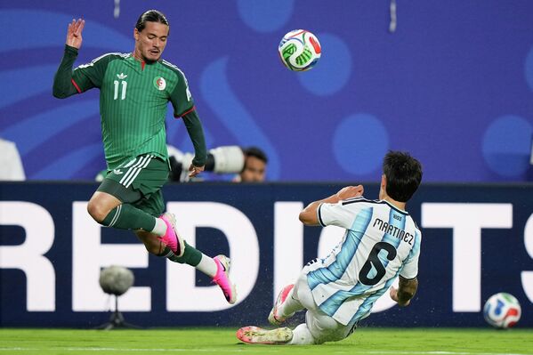 يتنافس اللاعب الجزائري أنيس حاج موسى والأرجنتيني ليساندرو مارتينيز على الكرة خلال مباراة كرة القدم ضمن المجموعة العاشرة من كأس العالم بين الأرجنتين والجزائر في مدينة كانساس سيتي بولاية ميسوري. - سبوتنيك عربي