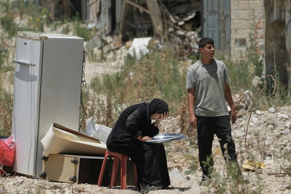 فلسطينيون يحمعون ممتلكاتهم من منازلهم التي تم إخلاؤها بعد أن أصدر الجيش الإسرائيلي تصاريح الدخول قصيرة الأجل لسكان مخيم طولكرم للاجئين في الضفة الغربية - سبوتنيك عربي