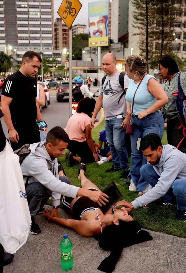 بعض الأشخاص يقدمون المساعدة لمرأة مستلقية على الأرض بعد زلزال في كاراكاس، فنزويلا. - سبوتنيك عربي