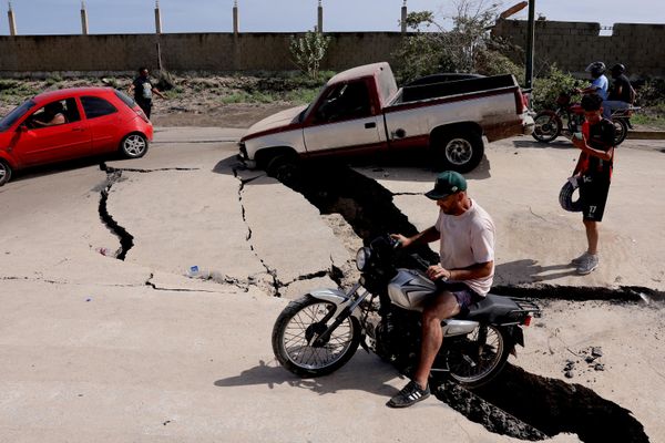 رجل على متن دراجة هوائية، على طريق متضرر، بعد أن ضرب الزلزال البلاد، في لا غوايرا، فنزويلا - سبوتنيك عربي