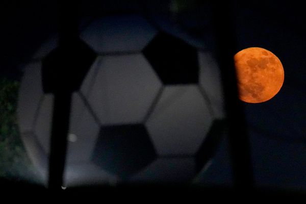 القمر يظهر خلف كرة قدم كبيرة تعلو محطة وقود احتفالا ببطولة كأس العالم لكرة القدم في أرلينغتون، تكساس. - سبوتنيك عربي