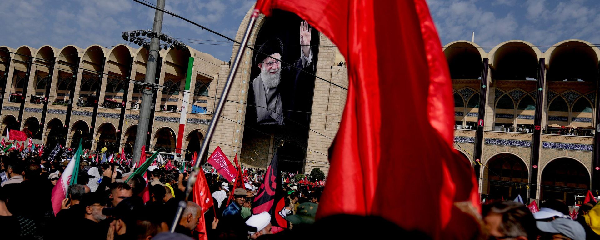 تُظهر الصورة حشودًا غفيرة من الإيرانيين يحملون الأعلام ويتجمعون أمام صورة المرشد الأعلى الإيراني الراحل، آية الله علي خامنئي، خلال مراسم التشييع. - سبوتنيك عربي, 1920, 04.07.2026