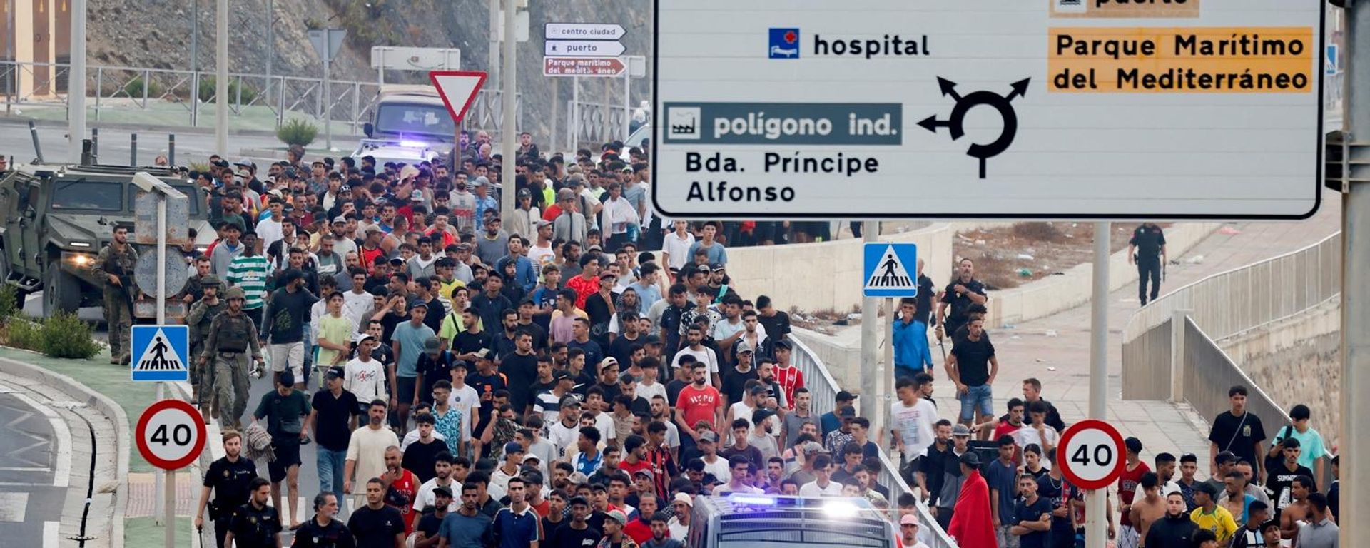 ضباط الشرطة والجنود الإسبان يرافقون مجموعة كبيرة من المهاجرين إلى الحدود لإخراجهم من إسبانيا، بعد عبور جماعي للمهاجرين سيرا على الأقدام وعن طريق البحر من المغرب إلى الأراضي الإسبانية، في سبتة، إسبانيا، 1 أغسطس/ آب 2026 - سبوتنيك عربي, 1920, 01.08.2026