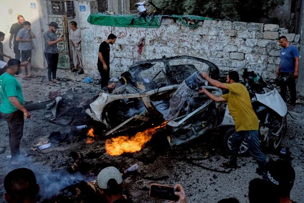 فلسطينيون يحاولون إخماد سيارة مشتعلة بعد غارة عسكرية إسرائيلية في مدينة غزة. - سبوتنيك عربي