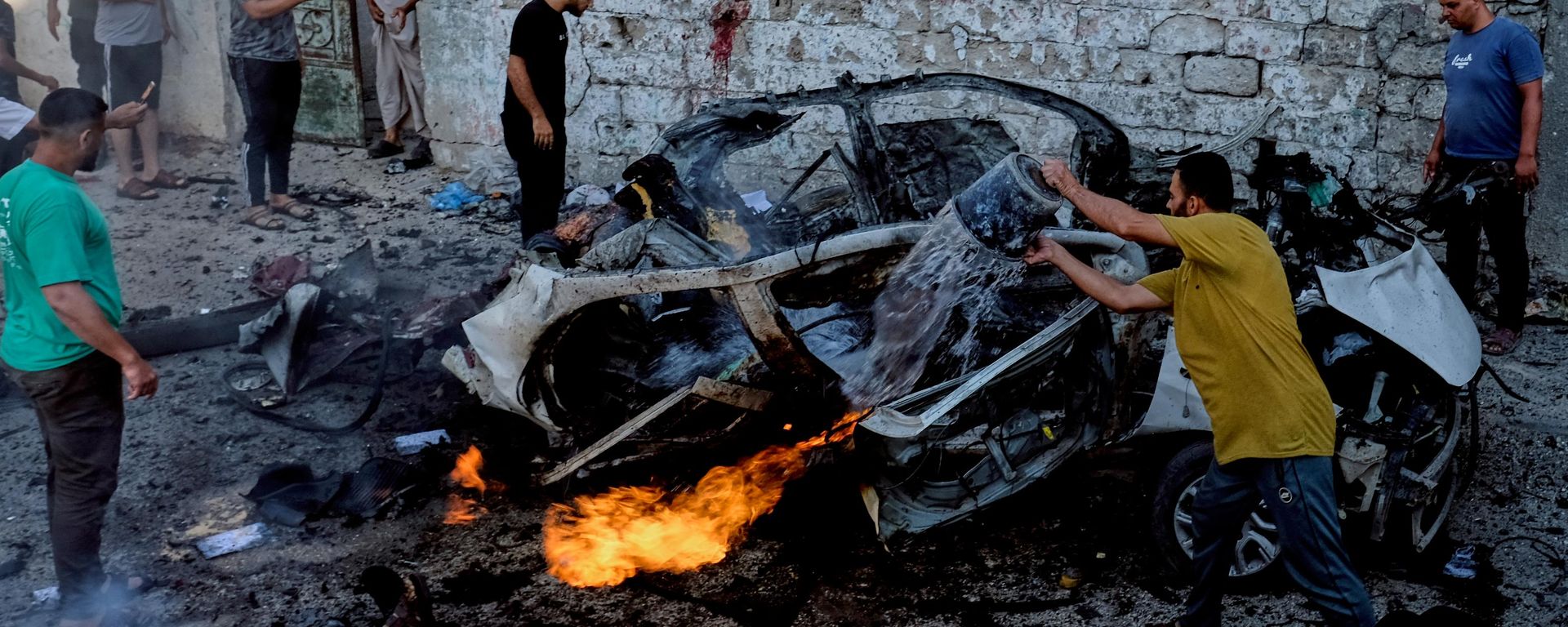 فلسطينيون يحاولون إخماد سيارة مشتعلة بعد غارة عسكرية إسرائيلية في مدينة غزة. - سبوتنيك عربي, 1920, 08.08.2026