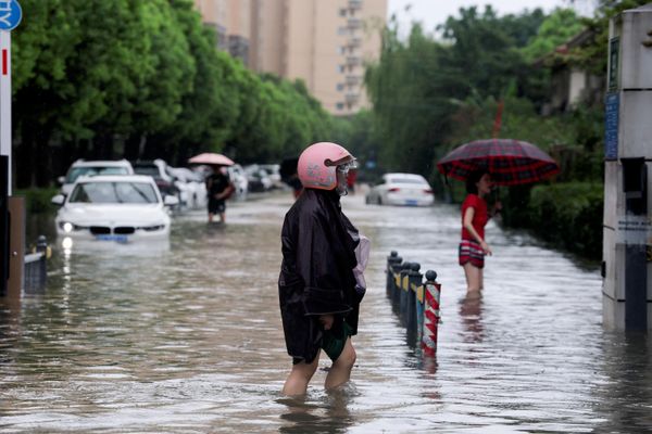 أشخاص يخوضون في شارع غمرته المياه بعد أن جلب إعصار دولفين أمطارًا غزيرة إلى شنغهاي، الصين، 10 أغسطس 2026. رويترز/جو ناكامورا. - سبوتنيك عربي