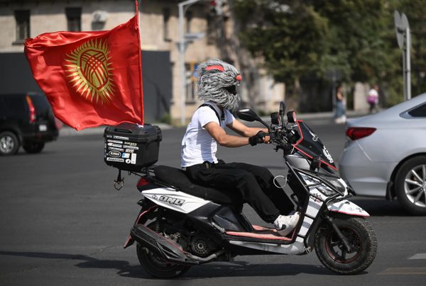 سائق دراجة نارية يحمل علم قيرغيزستان في بيشكيك، بالتزامن مع انطلاق قمة "شنغهاي". - سبوتنيك عربي