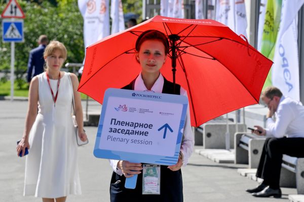 متطوع يستقبل الضيوف في المنتدى الاقتصادي الشرقي. لعام 2026 بلافتة توجههم إلى موقع الجلسة العامة. - سبوتنيك عربي