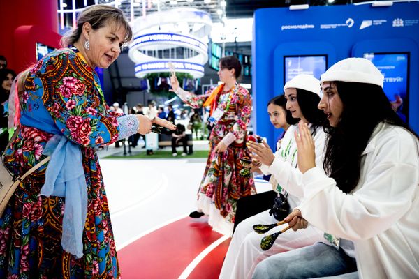 مشاركات يرتدين أزياء تقليدية ملونة ويتفاعلن مع بعضهن بعضا في فعاليات المهرجان. - سبوتنيك عربي