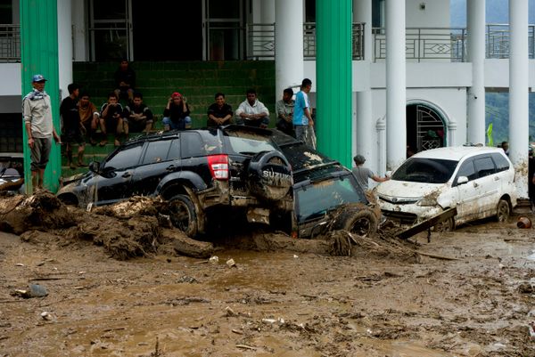 أشخاص يتجمعون بالقرب من سيارات متضررة في منطقة اجتاحتها سيول مفاجئة عقب هطول أمطار غزيرة في سولوق، مقاطعة سومطرة الغربية، إندونيسيا، 22 سبتمبر 2026. - سبوتنيك عربي
