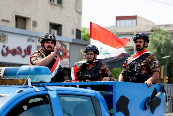 عناصر من قوات الأمن العراقية، على متن إحدى السيارات، يضعون العلم العراقي على صدورهم فيما يرفع أحدهم إشارة النصر، وذلك خلال مشاركتهم في موكب جاب شوارع بغداد احتفالاً بانسحاب قوات "التحالف"  - سبوتنيك عربي