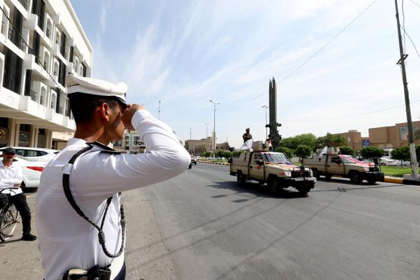 شرطي مرور يؤدي التحية خلال مرور موكب سيارات قوات الأمن العراقية في أحد شوارع بغداد - سبوتنيك عربي