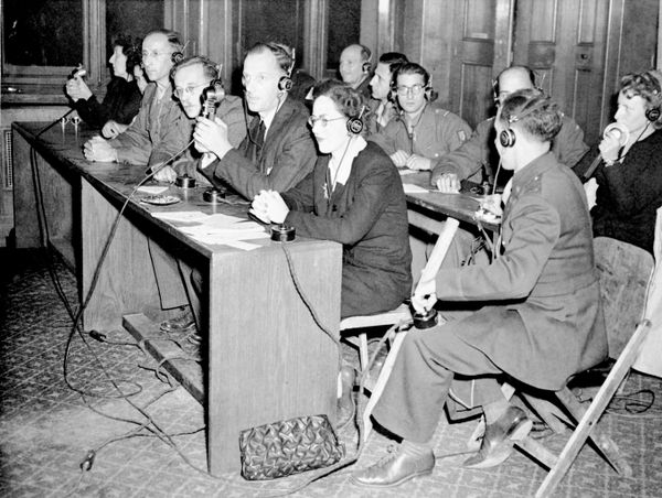 خلال "محاكمة صورية" في محكمة نورمبرغ بألمانيا، في 18 نوفمبر/تشرين الثاني 1945، استعرض مترجمون من الدول الأربع آلية الترجمة الفورية لوقائع المحاكمة إلى أربع لغات. وأتاحت سماعات الرأس ونظام التحكم للحاضرين اختيار الترجمة التي يرغبون في متابعتها. - سبوتنيك عربي