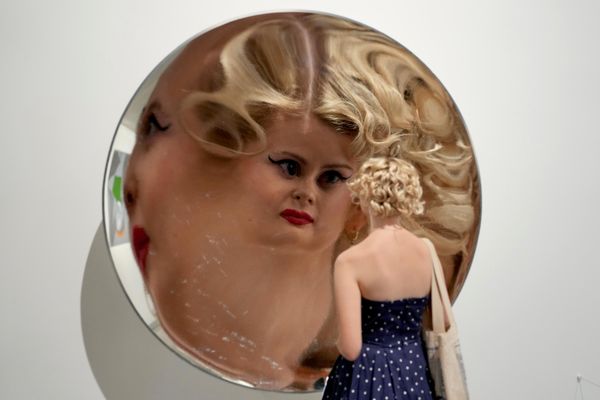 A زائرة تنظر في مرآة تشكل جزءاً من العمل الفني "Inverse Reverse Perverse" للفنان سيريث وين إيفانز، المعروض خلال معاينة إعلامية لمعرض "التسعينيات: الفن والموضة" في متحف "تيت بريتين" في لندن، يوم الثلاثاء، 6 أكتوبر 2026. (صورة من أسوشيتد برس/كين تشيونغ). - سبوتنيك عربي