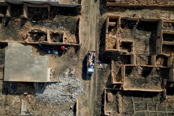 شاحنة تقل سكانًا عائدين مع ممتلكاتهم أثناء مرورها بمحاذاة مبانٍ مدمرة في قرية العريشة بريف رأس العين في سوريا - سبوتنيك عربي